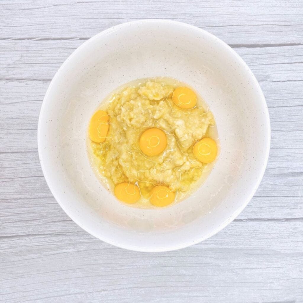 Eggs in a bowl together with mashed banana