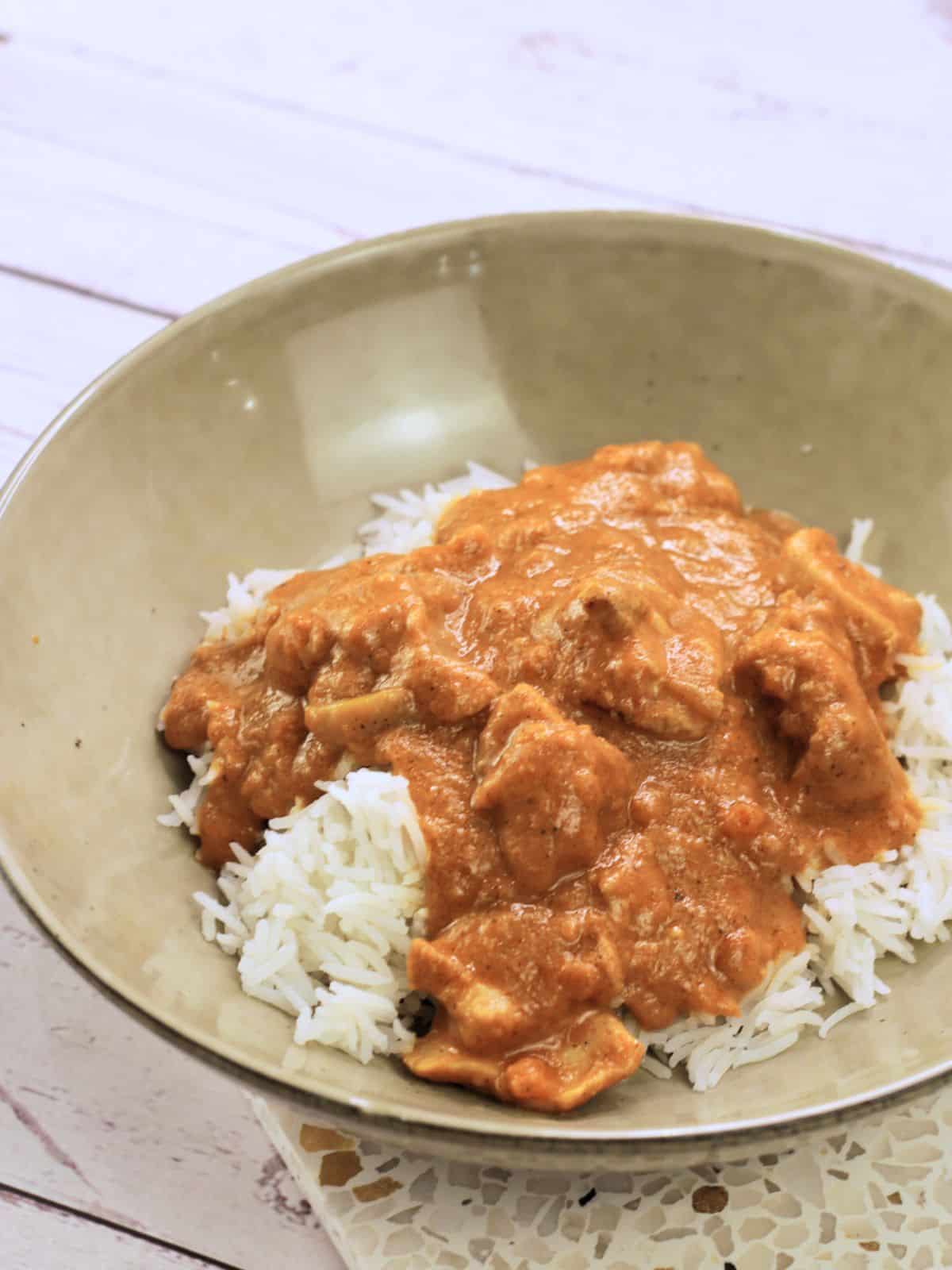 Ceramic bowl with rice and chicken curry in it