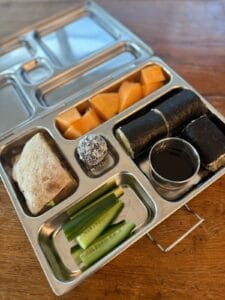 Healthy stainless steel bento lunchbox with sandwich, sushi and bliss ball